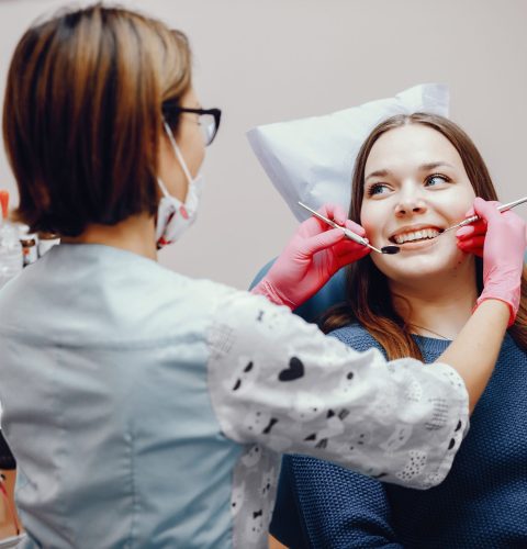Girl talking to the dendist. Beautiful lady in the dentist's office. Woman in a uniform